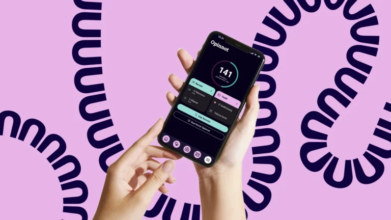 Puhelin, jossa Tuudo auki, pinkillä taustalla